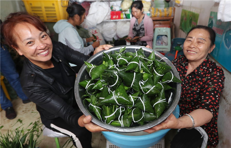 Two women display their hand-made Zongzi at the Zhuanxin market in Kunming, Yunnan province, June 1. 