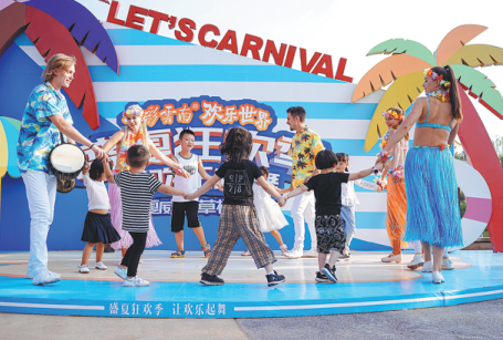 Foreign employees dance with children at Colorful Yunnan Paradise, a theme park in Kunming, Yunnan province