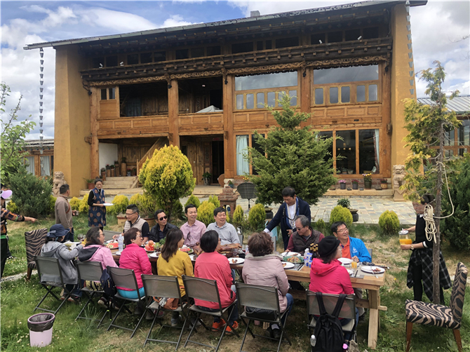 Guests enjoy a meal in the yard of Dakpa Kelden's home in Shangri-La