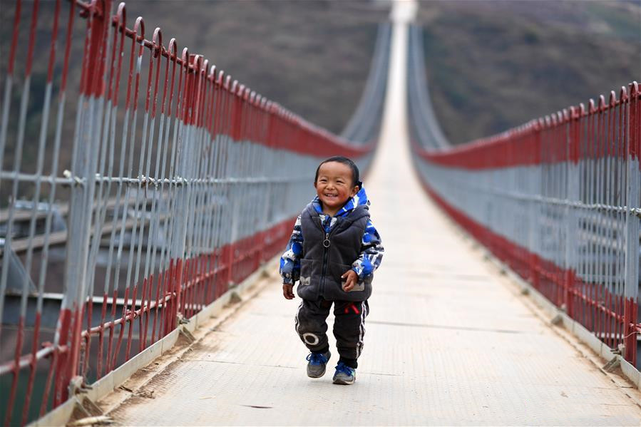 A child walks on a bridge spanning the Niulan River in southwest China on Dec. 11, 2019