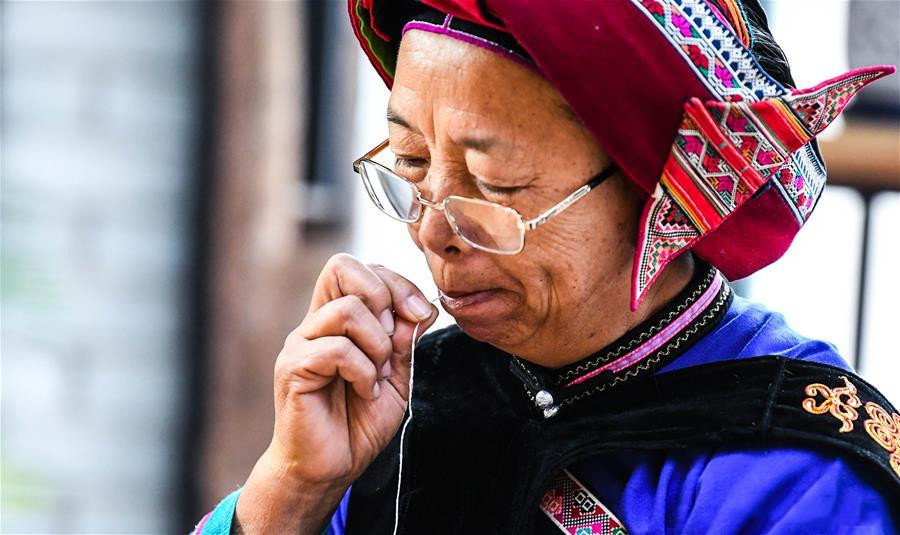 National intangible cultural heritage inheritor Bi Yueying makes embroidery at her workshop in Shilin county of Kunming, Yunnan